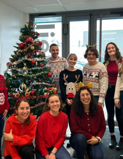 Plusieurs employ&eacute;s posent autour du sapin de No&euml;l de l'entreprise.